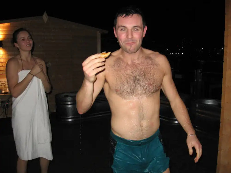 Man in a sauna holding a pastry after a social sauna event in London