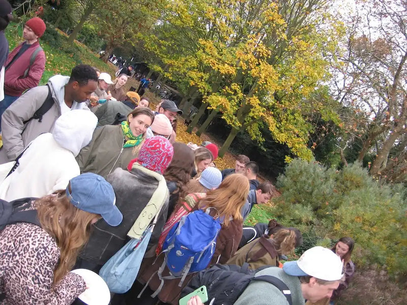 Group of London swim club members in a park with trees and autumn foliage