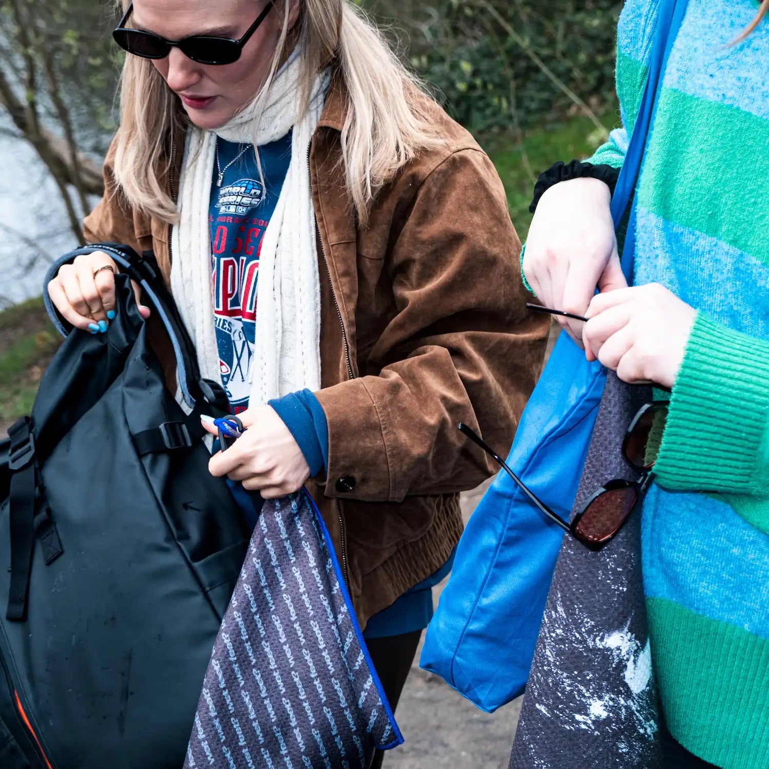 Two urban swimmers attaching the Swim Peeps Dry Step Swim Changing Mat to their swim bags